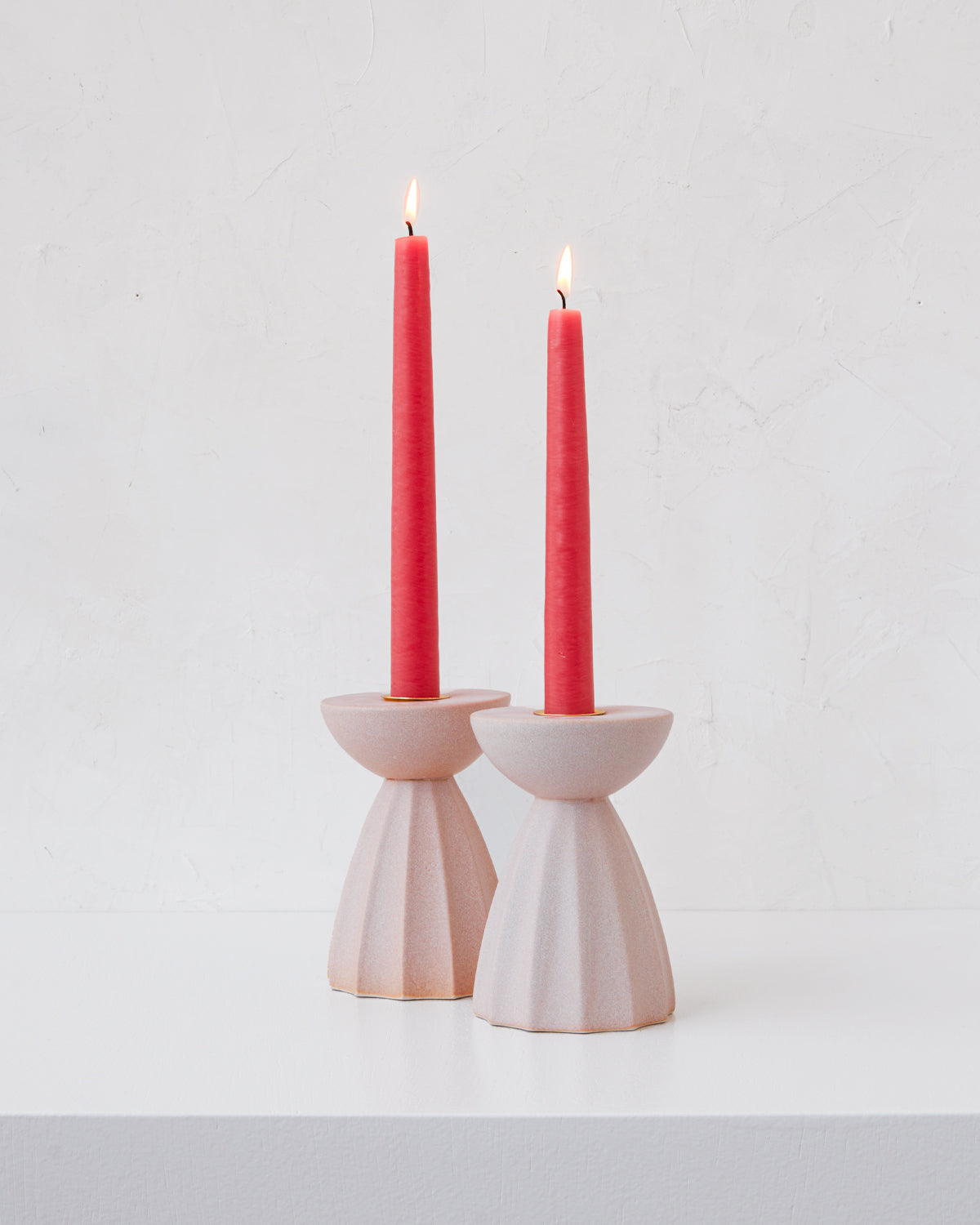 Blush Sabine ceramic candle holder with fluted ridged base in matte pink glaze with hot pink taper candles