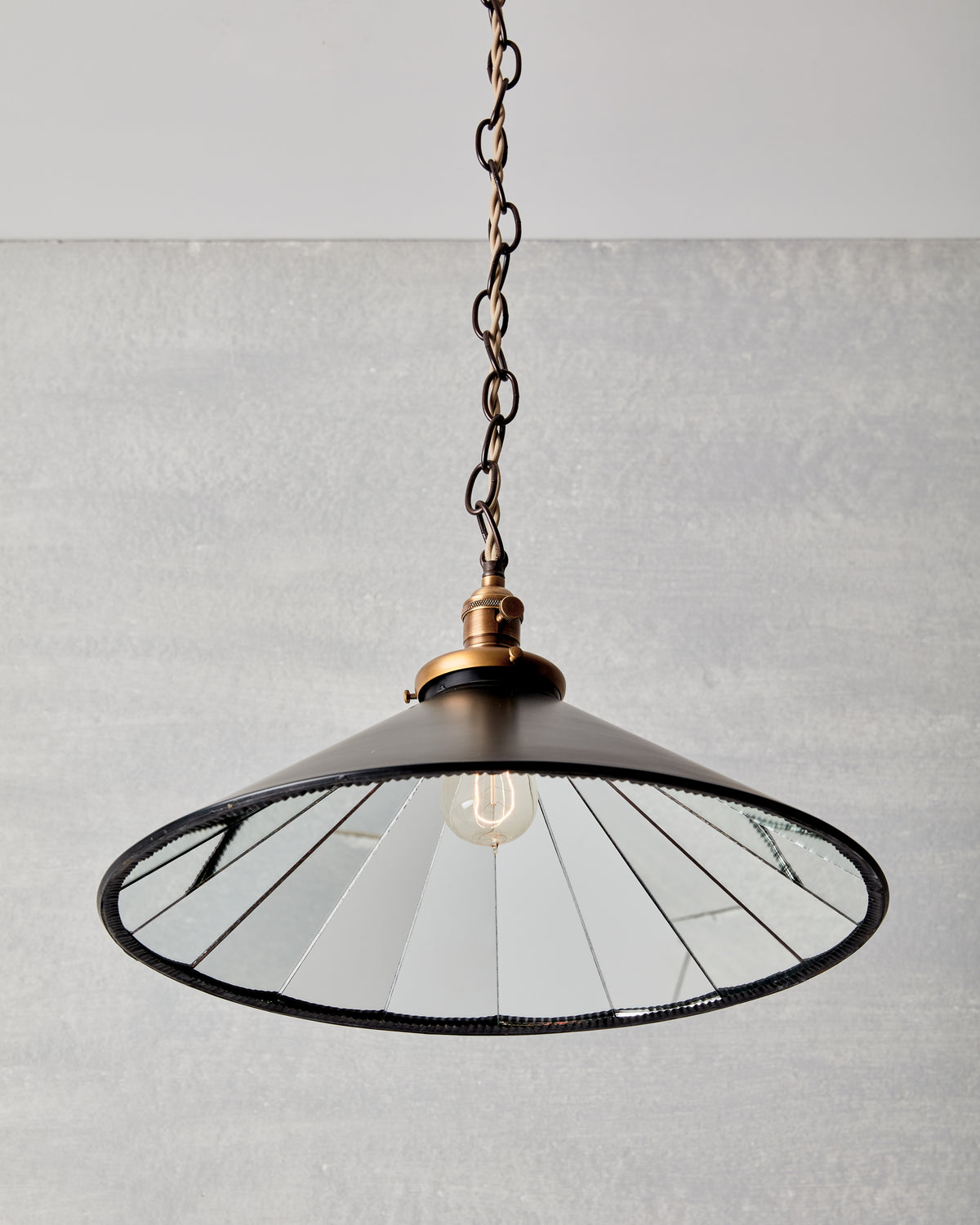 Classic large modern mirrored cone pendant with oil rubbed brass chain.  Hardwired light fixture. Simple interior design, made in the USA.
