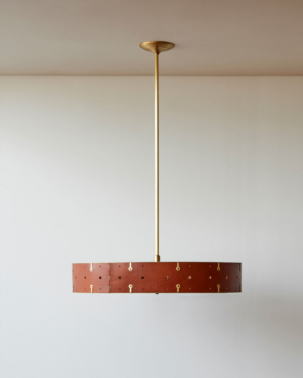 Beautiful satin brass ceiling pendant fixture with handstitched leather drum shade and customizable drop
#leather-color_tan harness #size_24" drum