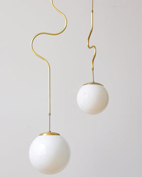Satin brass Contour ceiling pendant lights made by Lostine in Philadelphia, Pennsylvania. Satin brass modern lighting design with white glass globe. Hardwired light fixture. Simple interior design, made in the USA.