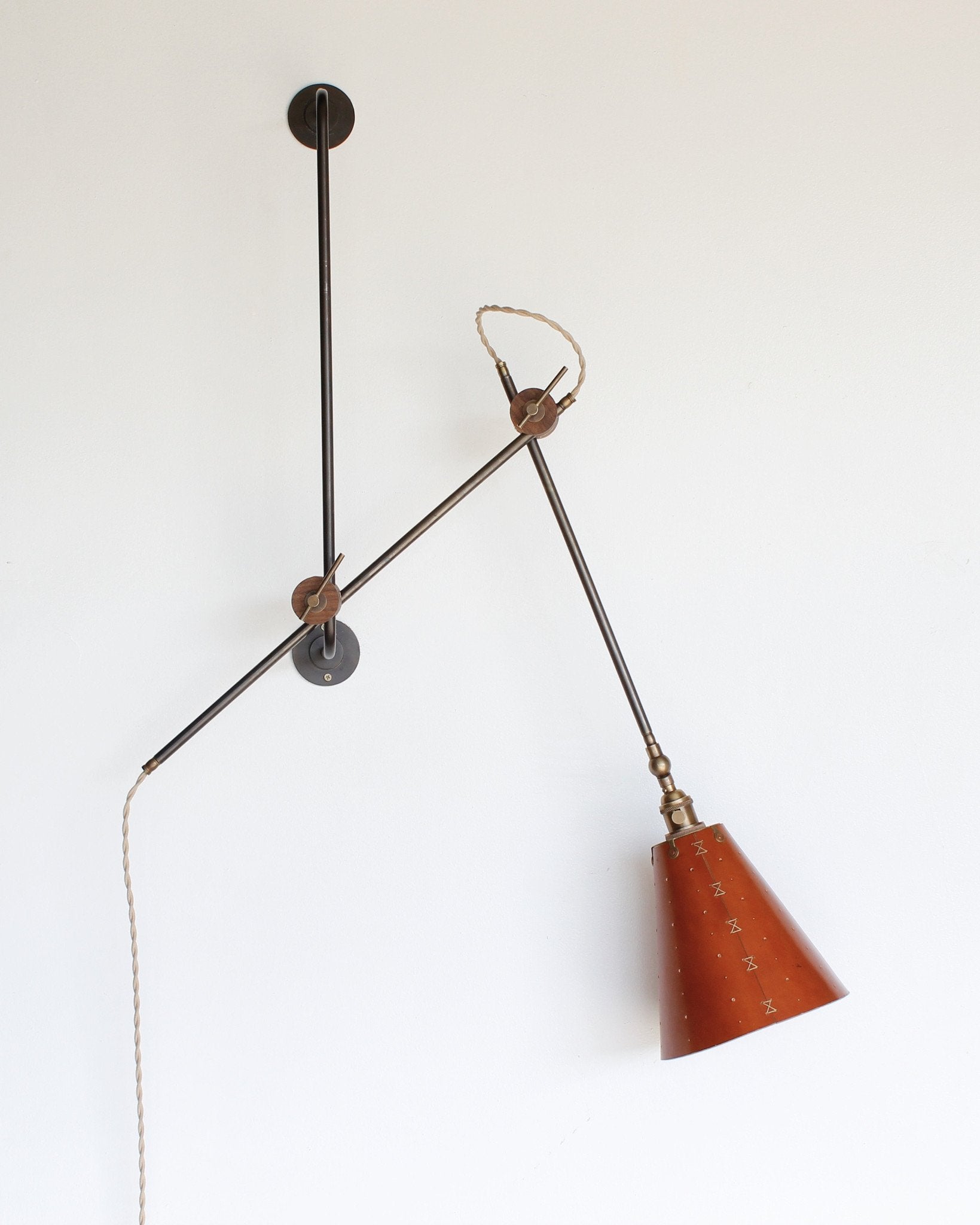 Large articulating black plug in wall sconce with tan handstitched cone leather shade