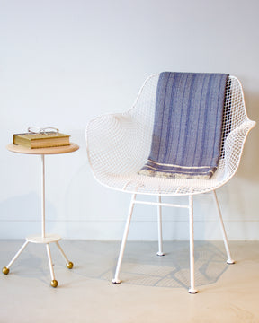 Modern tripod white side table with book and glasses next to white wire Biscayne chair and blue blanket. Handmade in Philadelphia by Lostine. Simple Interior Design